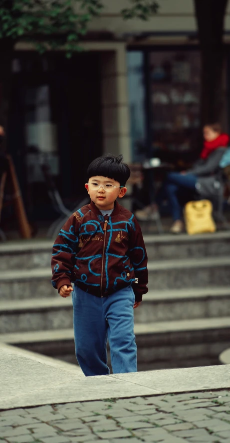 a small child walks on a sidewalk outside