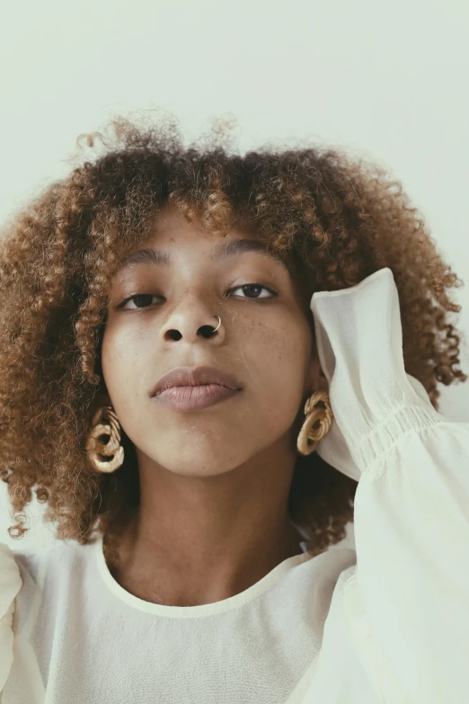 an african american woman with natural hair in a cream top