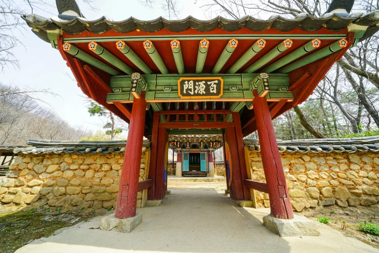 a large arch with two small pillars with a clock on it