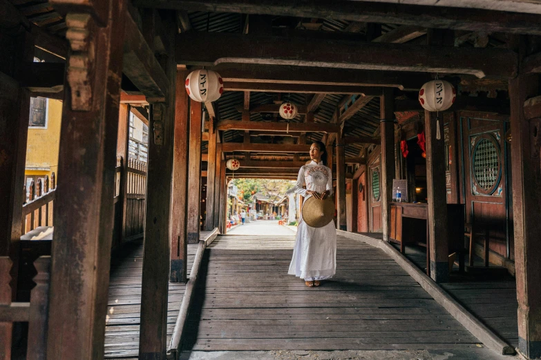 a woman in a white dress walks down a path