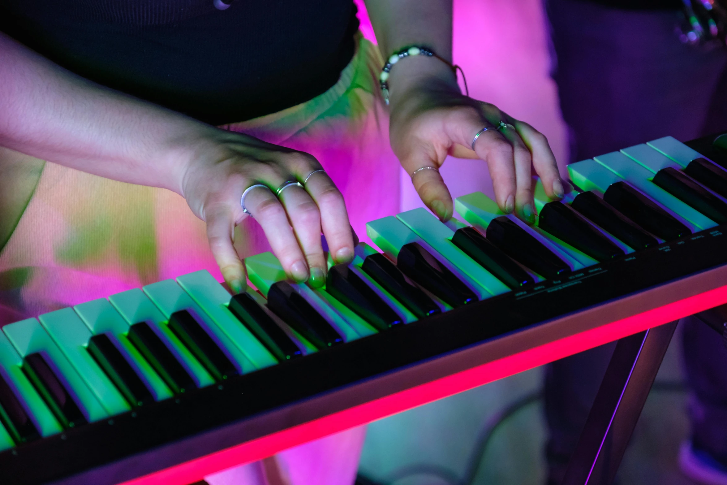 the hands of a woman playing an electronic keyboard