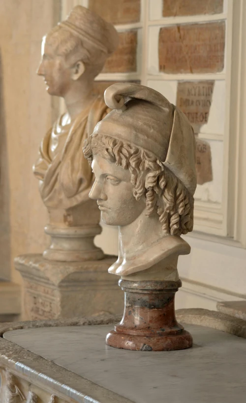 some white marble busts with a white head and other faces on them