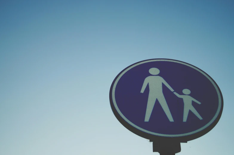 a blue and white sign that has a man holding the hand of a child