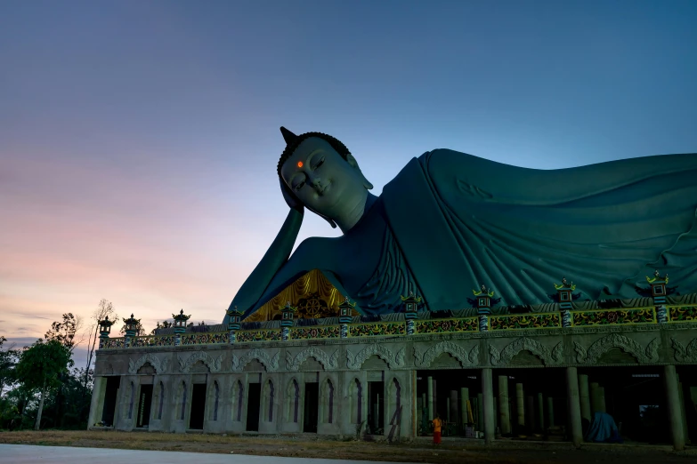 an enormous buddha statue standing in the sunset