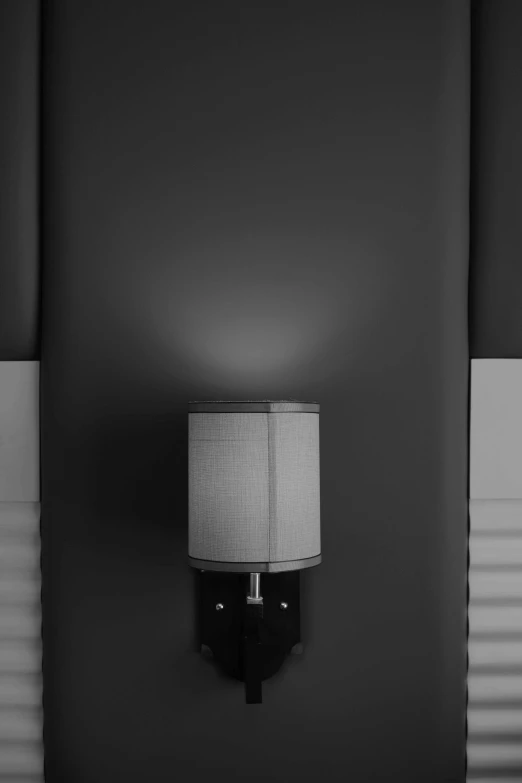 a lamp is on in front of a black wall