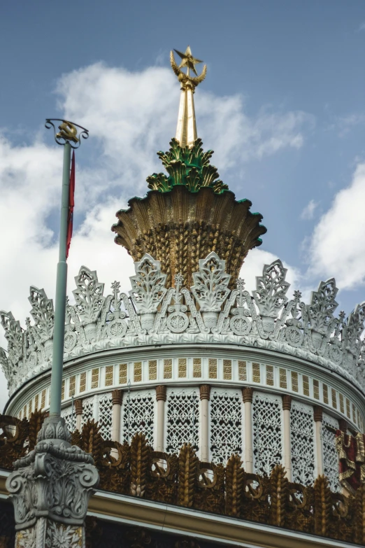 a gold statue of an angel sitting on top of a domed structure