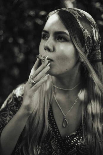 a woman in a head scarf eating soing and smoking