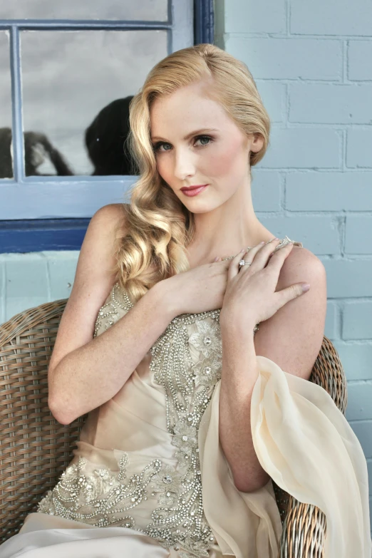 woman with blond hair posing on wicker chair