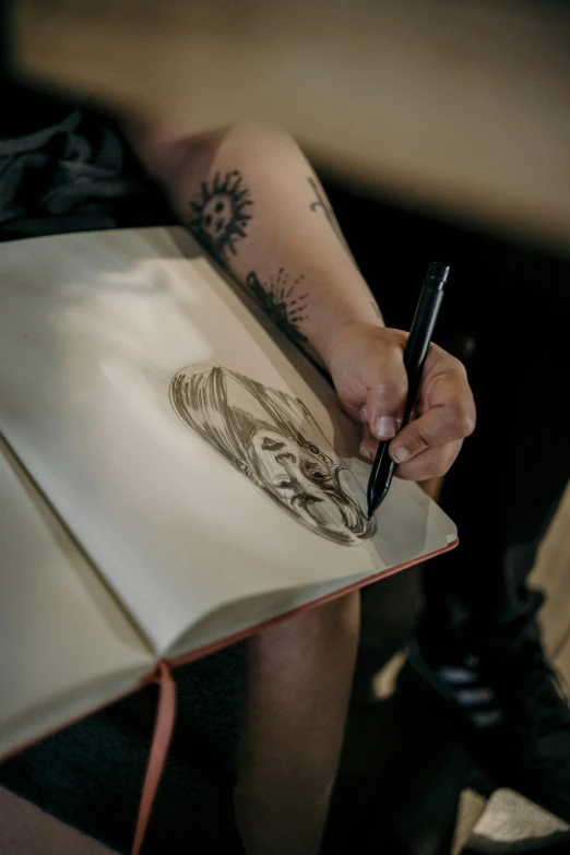 someone drawing with a pencil while sitting down