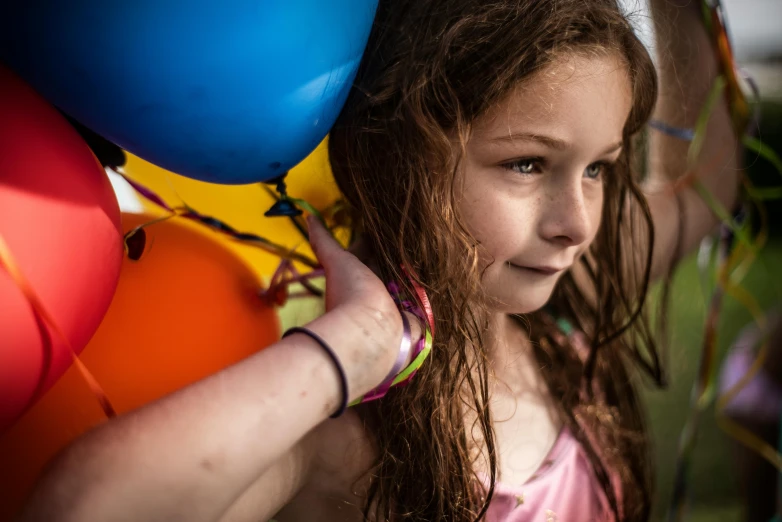 a girl holding balloons over her head