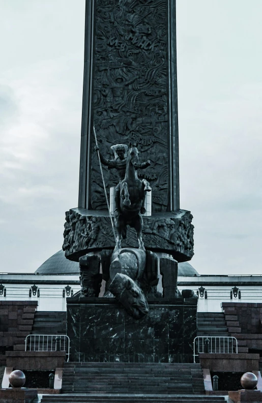 a statue with a large clock tower in the background