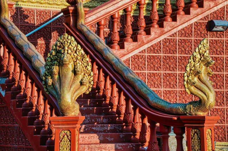 a long wooden railing with decorative art work on it