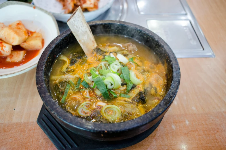 some vegetables and soup in a black bowl