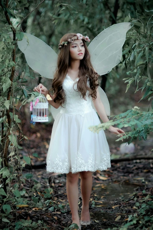 the fairy is standing outside and holding an object