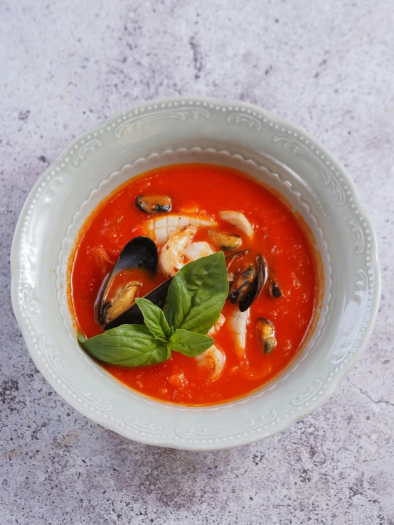 there is a white bowl with seafood and some water on the table