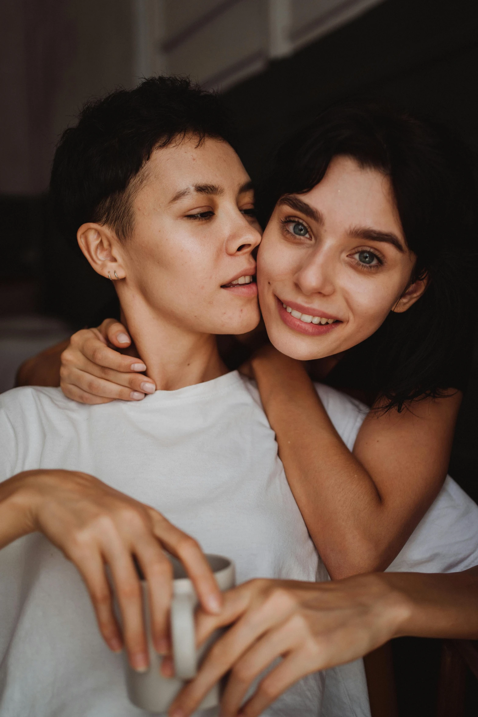 two woman hugging each other while looking at the camera