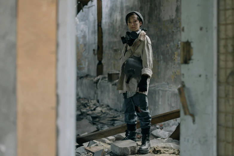 a woman wearing knee - high boots standing in front of rubble