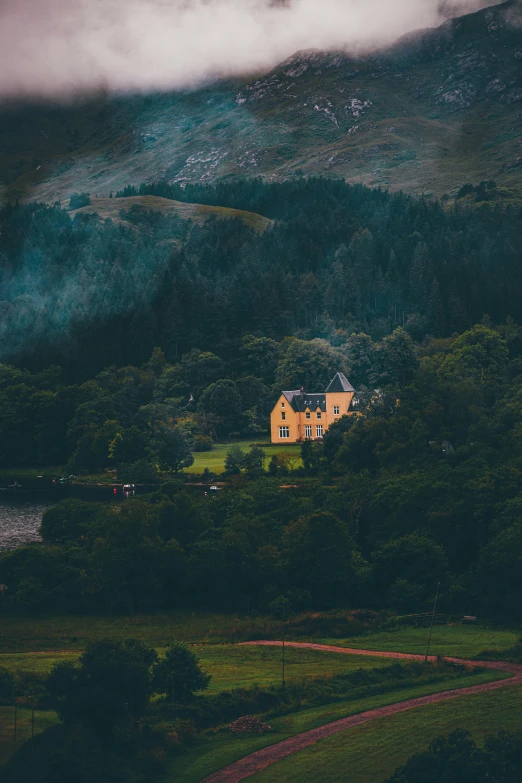 a red house with mountain in background in cloudy weather