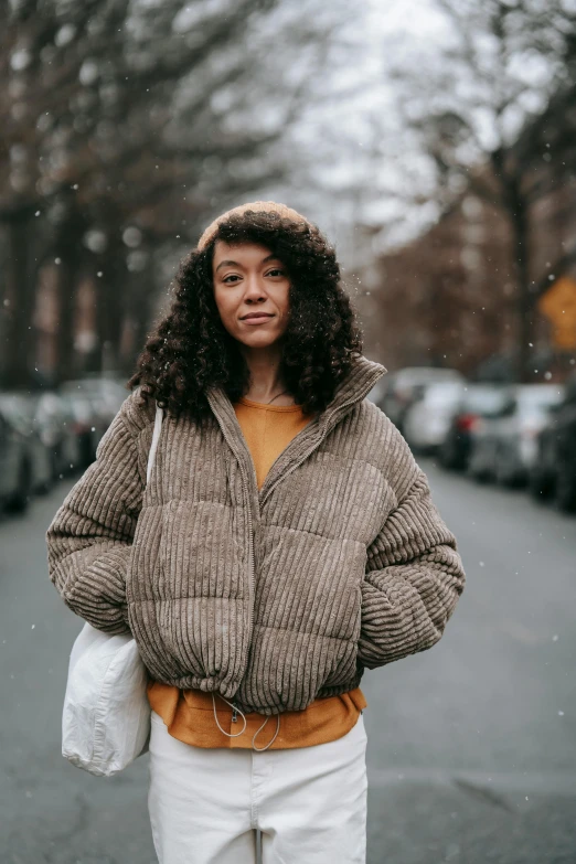 a woman is standing in the street during a snow storm