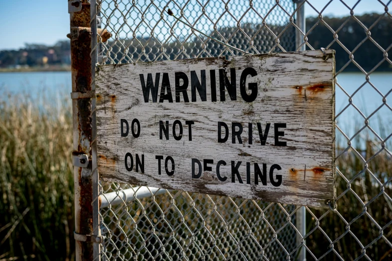 a sign that is on top of a chain link fence