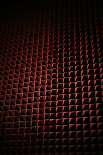 dark background image of a red wall with a small grid