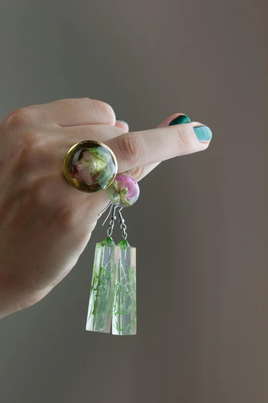 a person holding on to a multi colored ring with flowers in it