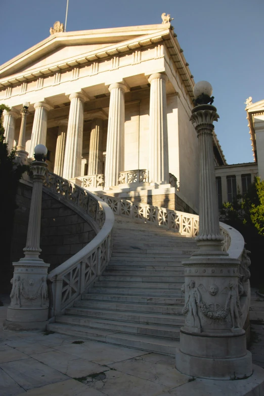 there is a building that has columns and statues on it