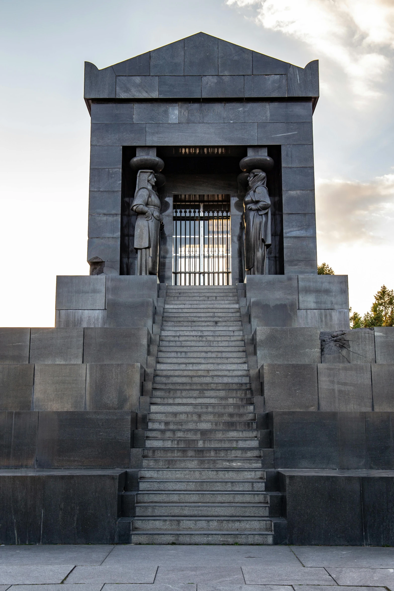 some stairs going to a building that has statues