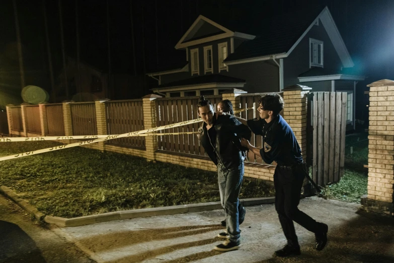 police officers are walking past a cord - wrapped driveway