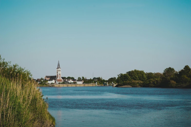 a body of water with trees and a clock tower in the background