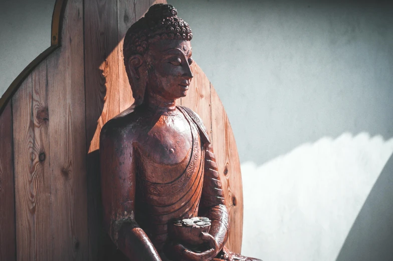 a wooden sculpture with its back turned to a buddha position