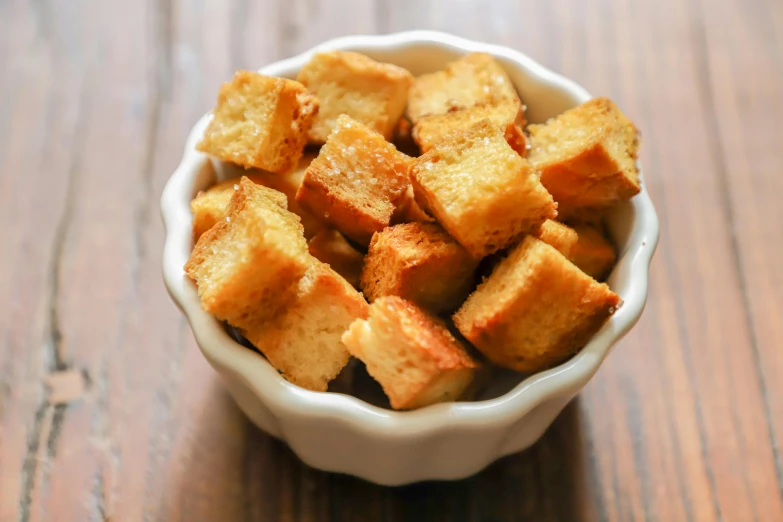 a white bowl filled with brown sugar cubes