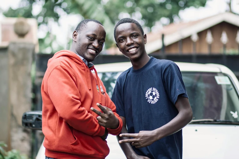 two men posing for the camera in front of a white van