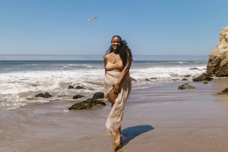 a woman walking along a sandy beach