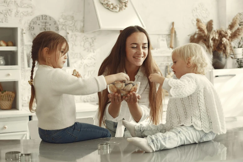 a  sitting on the floor with her two older girls