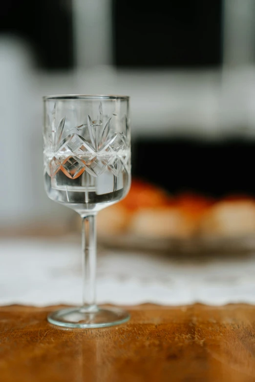 a wine glass with ice cubes in it on a wooden table