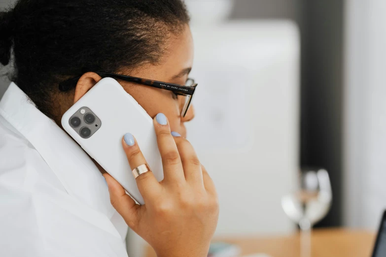 a woman with glasses using her phone to call someone