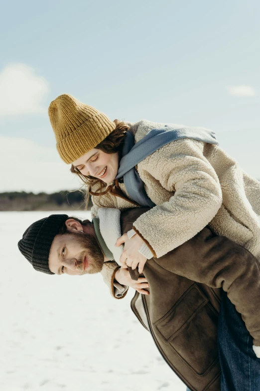 a man and woman are outside in the snow