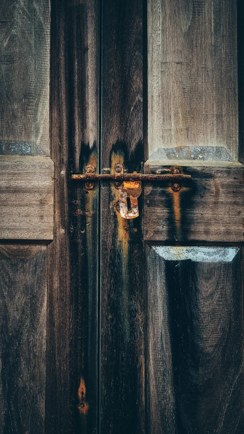 an old brown wooden door is open and there is only one key