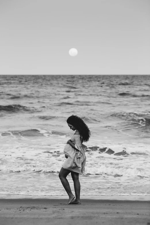 a woman is running on the beach towards the ocean