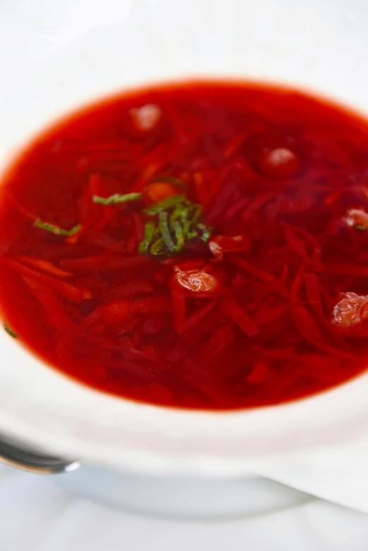 a bowl of soup with carrots, broth, and spinach