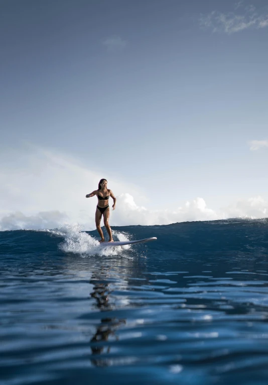 a woman is standing on a surfboard in the water