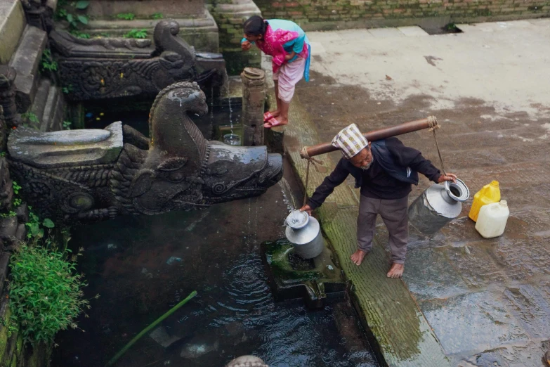 the women are using buckets to clean the water