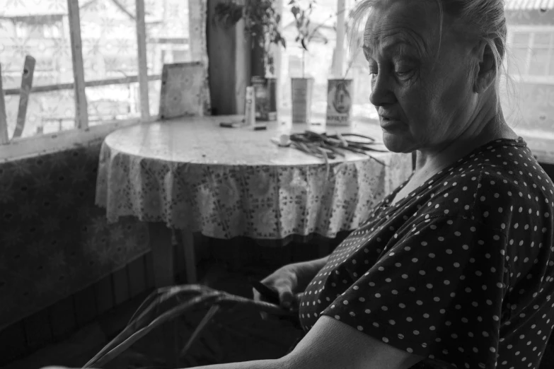 a woman sitting at a table with scissors in her hands