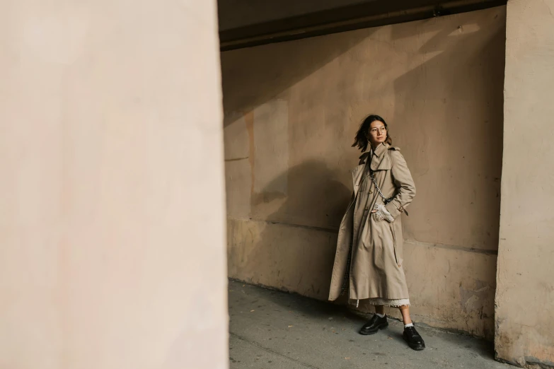 a woman standing in front of a building and a stone wall