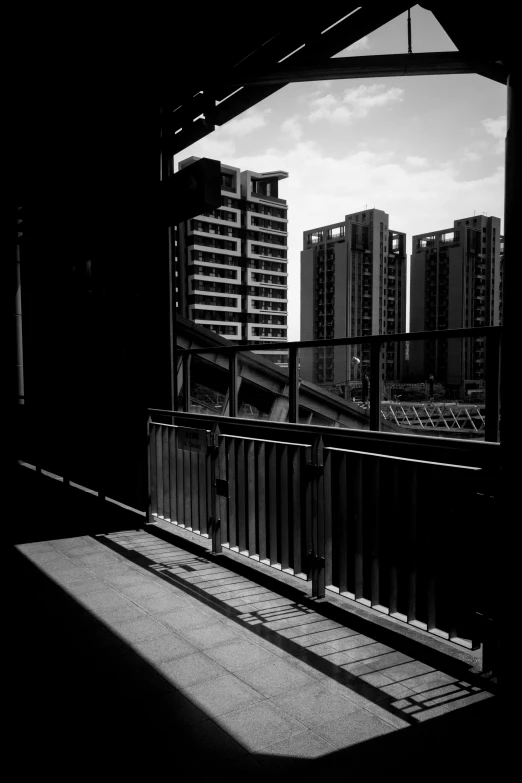 black and white pograph of city buildings seen from a bridge