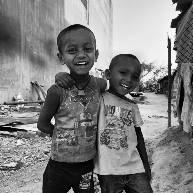 two small children one standing up with his head next to another