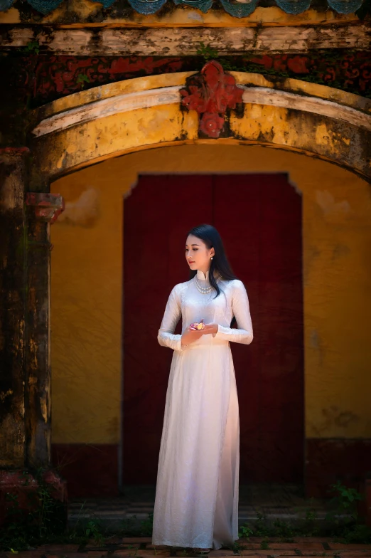 asian lady wearing a white dress with an elaborate doorway