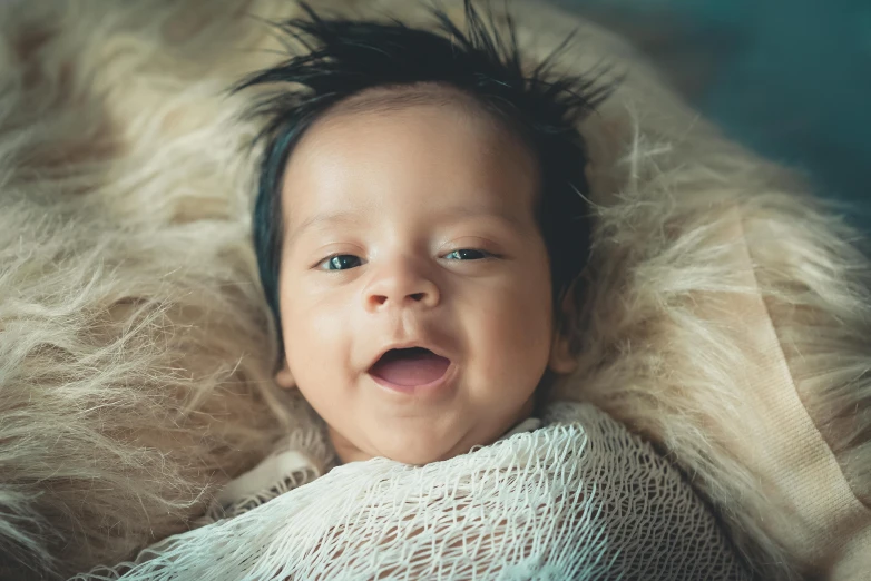 an infant with gy hair smiling and laying down