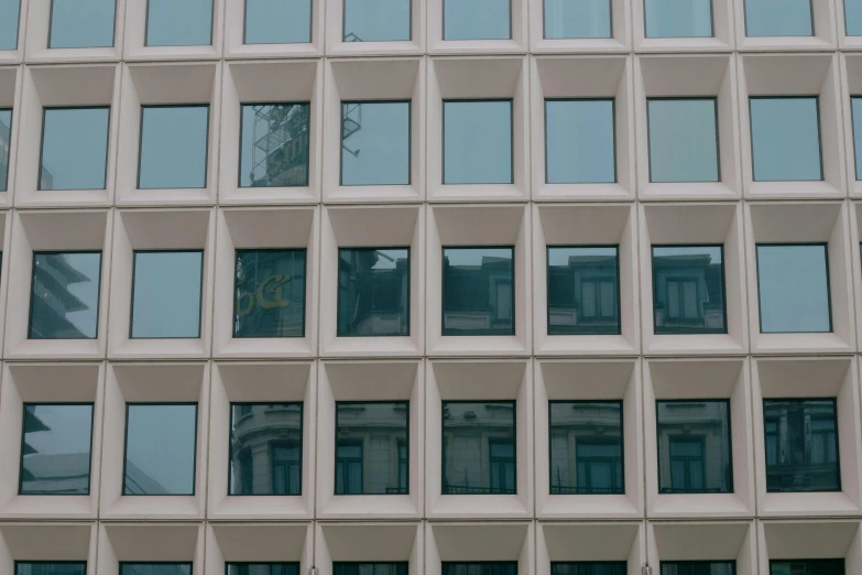 the windows of an office building with a clock on the outside